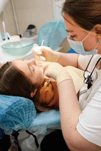 Dentiste ou hygiéniste dentaire traitant un jeune patient.